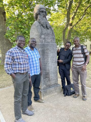 Image taken by Matthias Krings: Patrick Oloko with three Kenyan colleagues in front of the bust of Johannes Gutenberg, at the university campus, Mainz. From left to right: Dr. Patrick Oloko, Dr. James Ogone, Dr. Fredrick Mbogo and Dr. Solomon Waliaula.